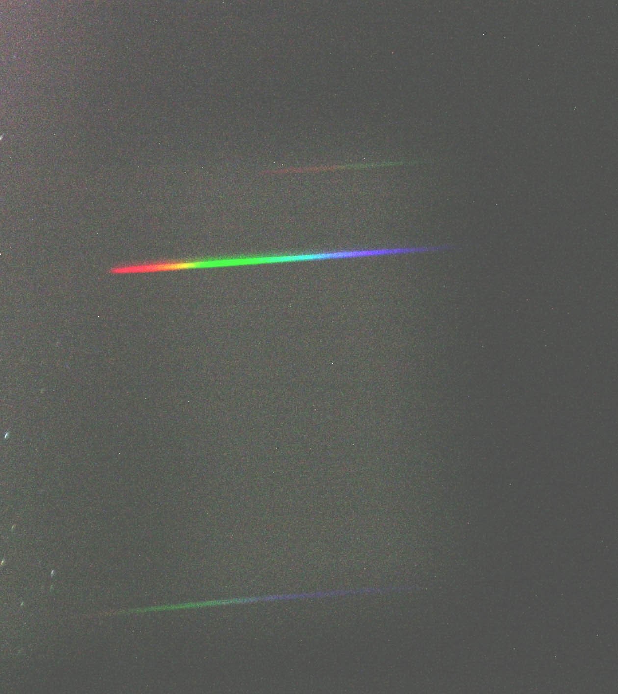 Con un prisma e una macchina fotografica digitale è possibile ottenere lo spettro delle stelle. Ad occhio nudo quasi tutte le stelle sembrano bianche; in realtà la loro luce contiene tutti colori dell'arcobaleno (spettro). Il bianco in realtà non esiste, è una nostra percezione ottenuta quando la nostra retina è colpita da tutti i colori dell'acobaleno (anche se in realtà sono sufficienti il rosso, il verde e il blu). Il prisma è un vetro a forma di piramide che è in grado di separare la luce bianca nei suoi componenti. Ponendo una macchina fotografica vicino ad esso - il tutto posto naturalmente su un cavalletto - è possibile registrare l'immagine di uno spettro stellare. È in questo modo che gli astronomi ricavano le caratteristiche delle stelle: temperatura, composizione, velocità, ecc. Ogni spettro di una stella è diverso dagli altri: su di esso si trovano delle righe nere che sono una specie di impronta digitale dell'astro. Nell'immagine lo spettro della Stella Polare. (testo e immagine Ochner)